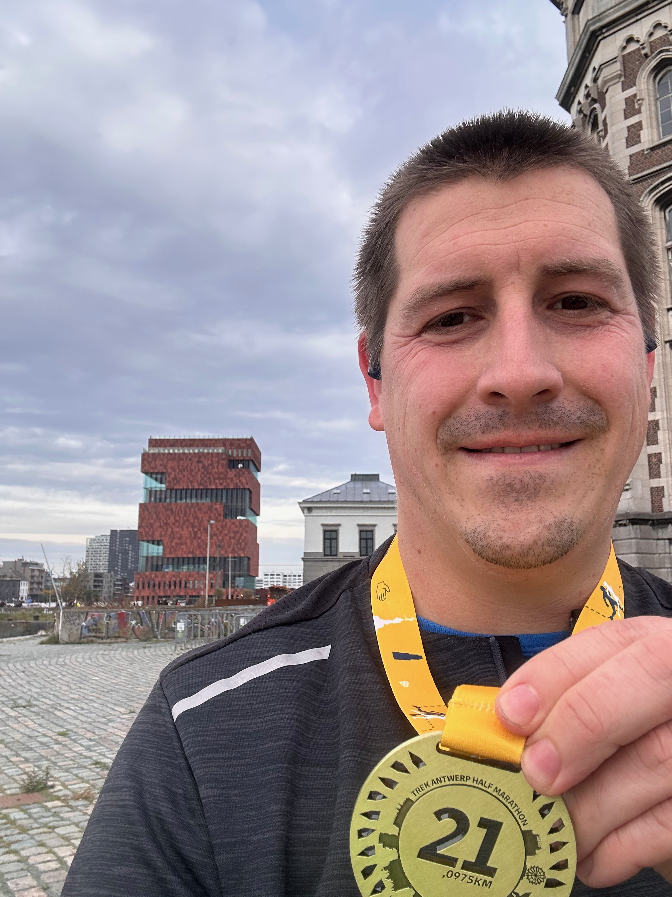 Runner holding an Antwerp Half Marathon 2025 medal after the race